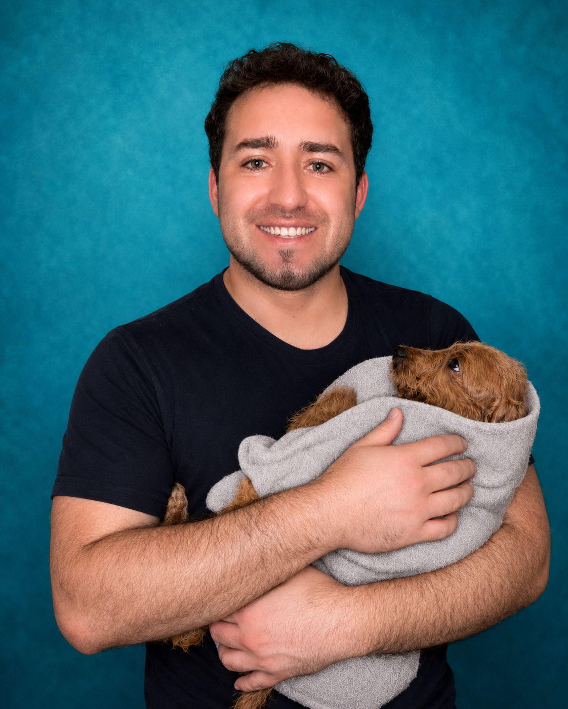 Andrey, founder and lead groomer, holding a small dog